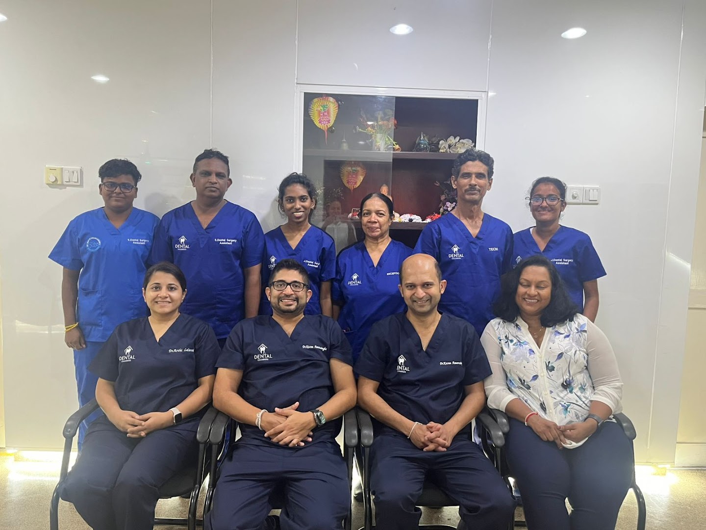 The Dental Chambers team in branded blue scrubs in the clinic waiting area